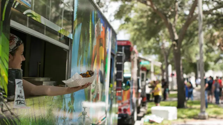 a row of food trucks at a downtown park