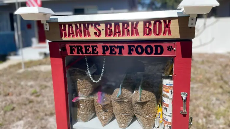 a dog food pantry set up on the side of the road offering free pet food for residents