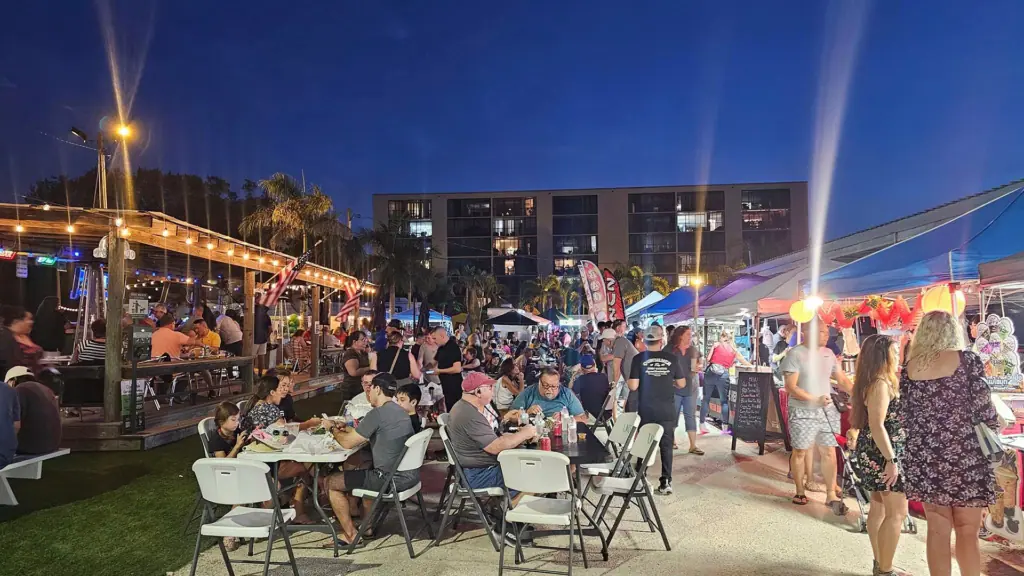 a group of people gather at a food festival under the stars