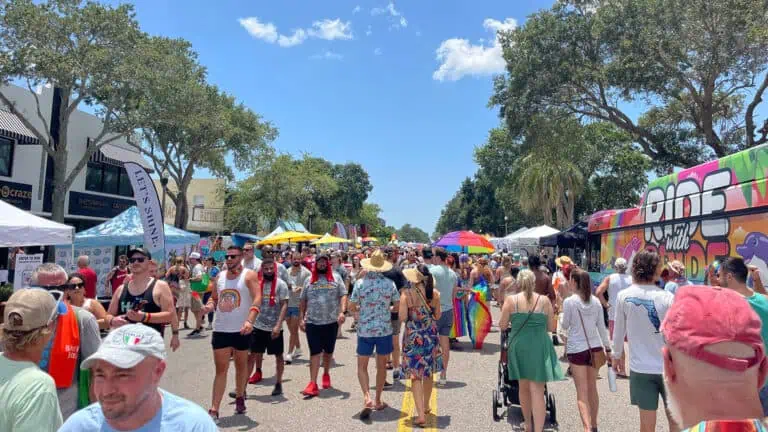 people gather for a street festival at a PRIDE celebration