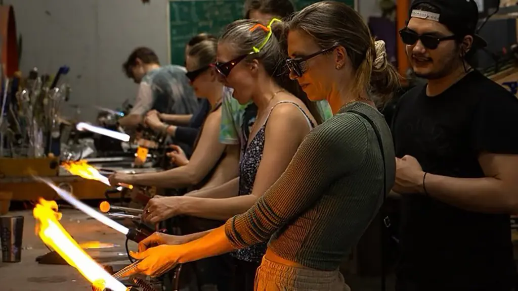 multiple people participate in a glassblowing workshop