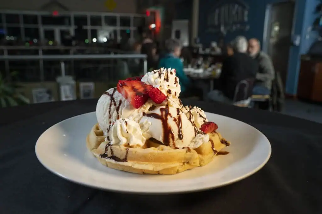 waffle covered in strawberries and ice-cream