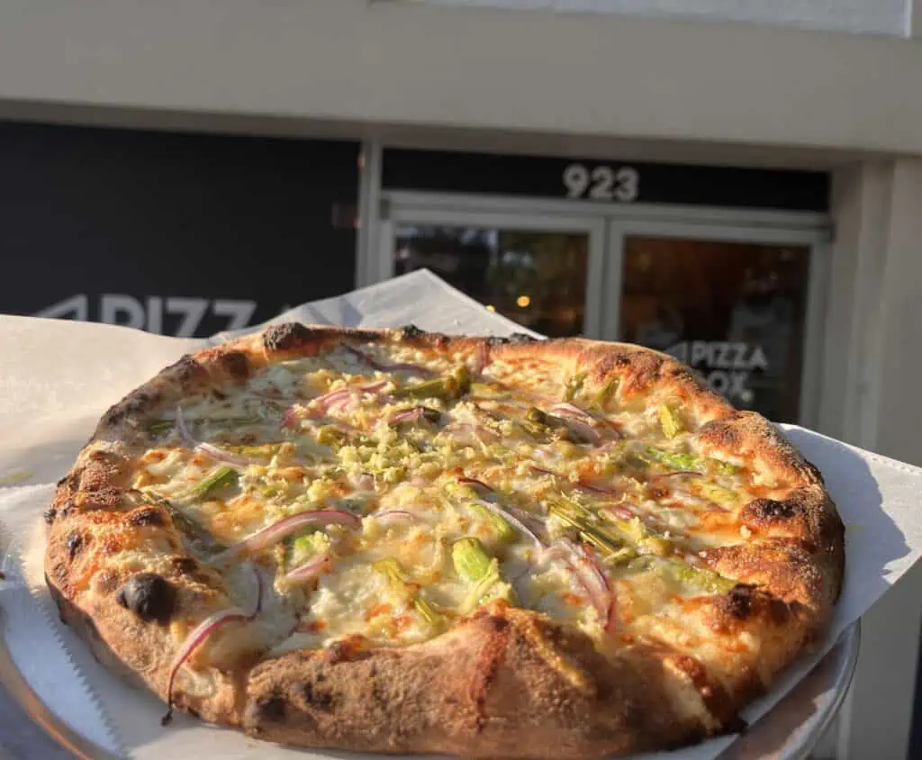 pizza on tray with paper underneath.