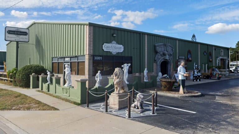 exterior of a large culinary warehouse with multiple chef statues out front