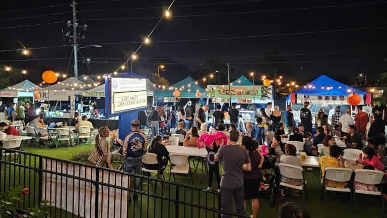 a group of vendors gather for a food festival under the stars
