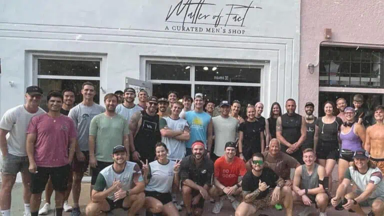 a group of runners pose in front of a men's clothing boutique