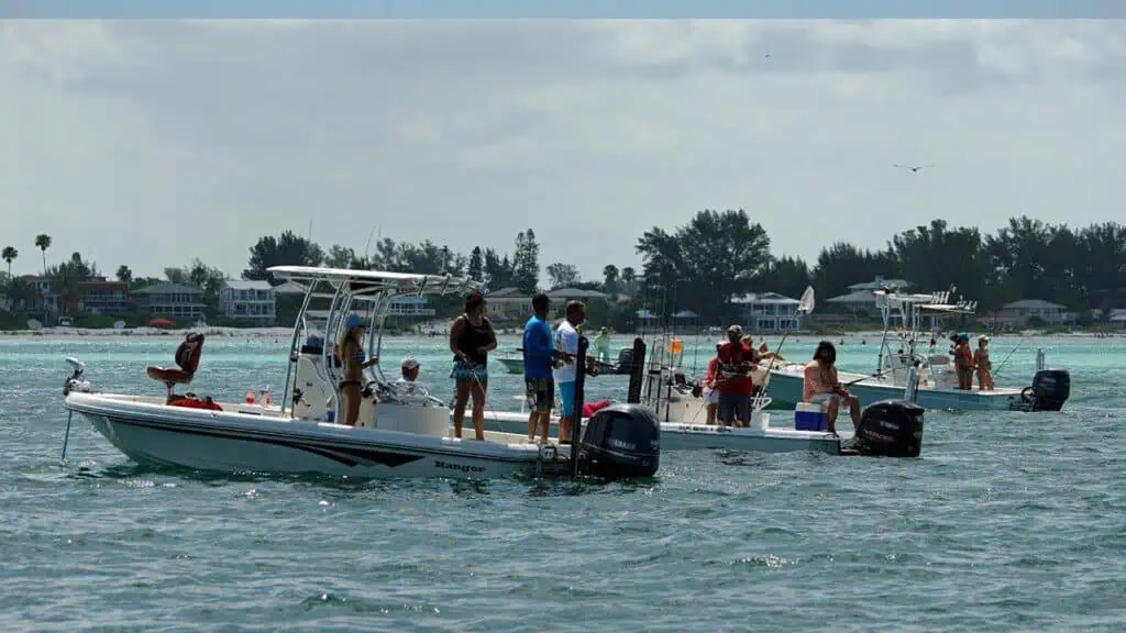 three boats in the water as multiple people fish