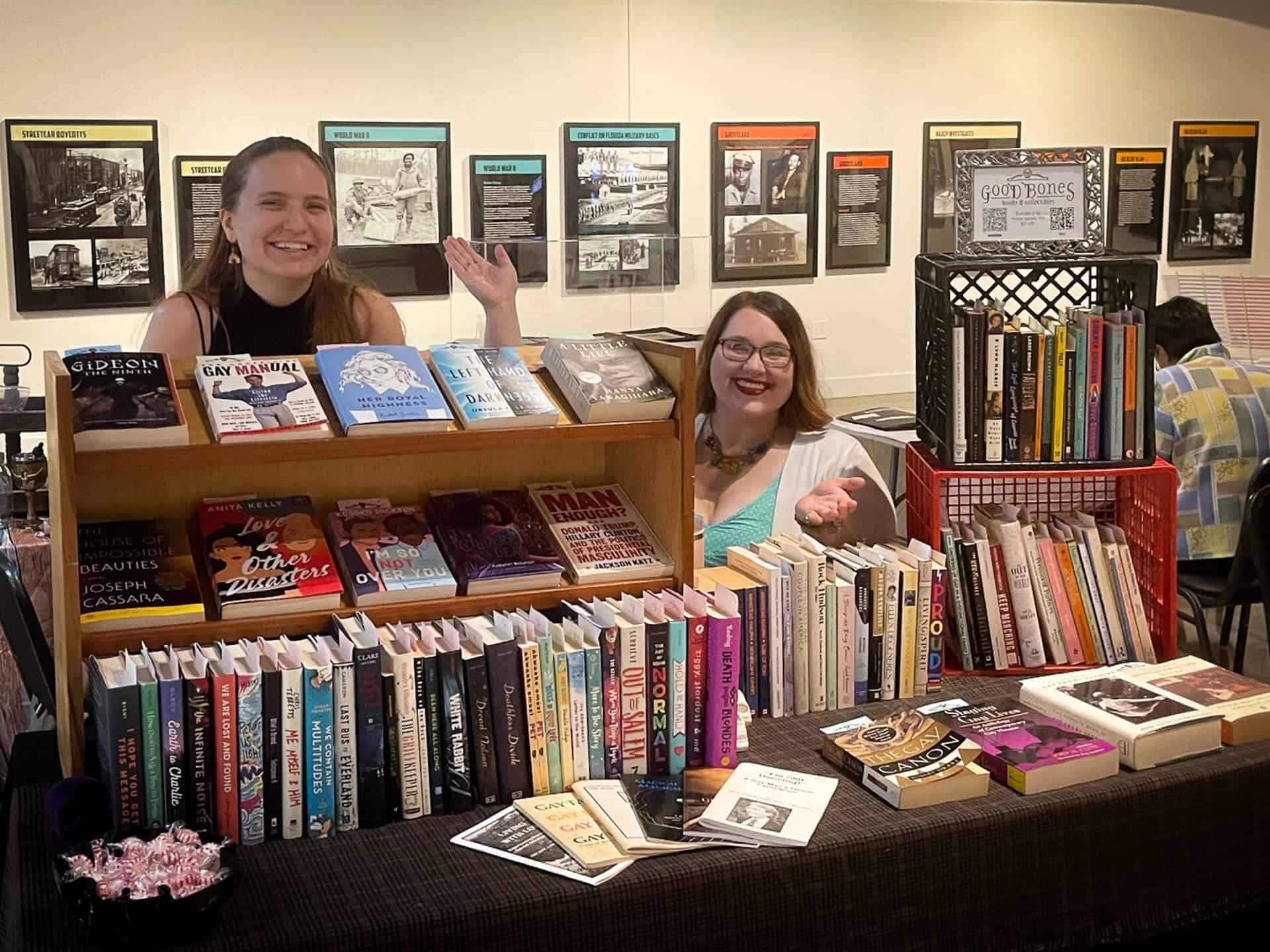 two booksellers behind a vendor booth at an event