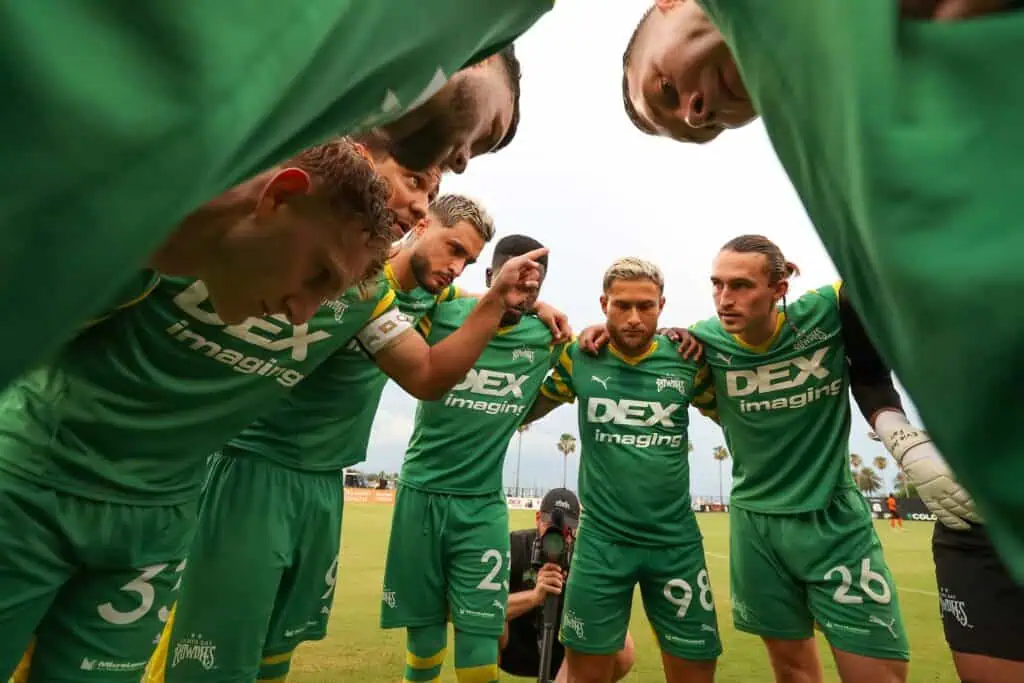 Rowdies players in a team huddle