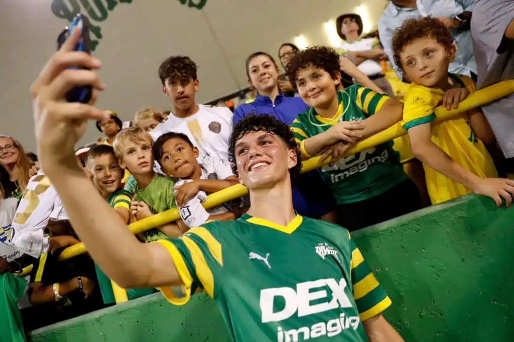a rowdies player signs autographs for fans