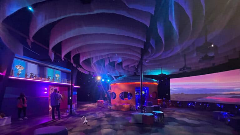 interior of an arts venue with a large cylindrical building at the center and a mock hurricane formed on the ceiling