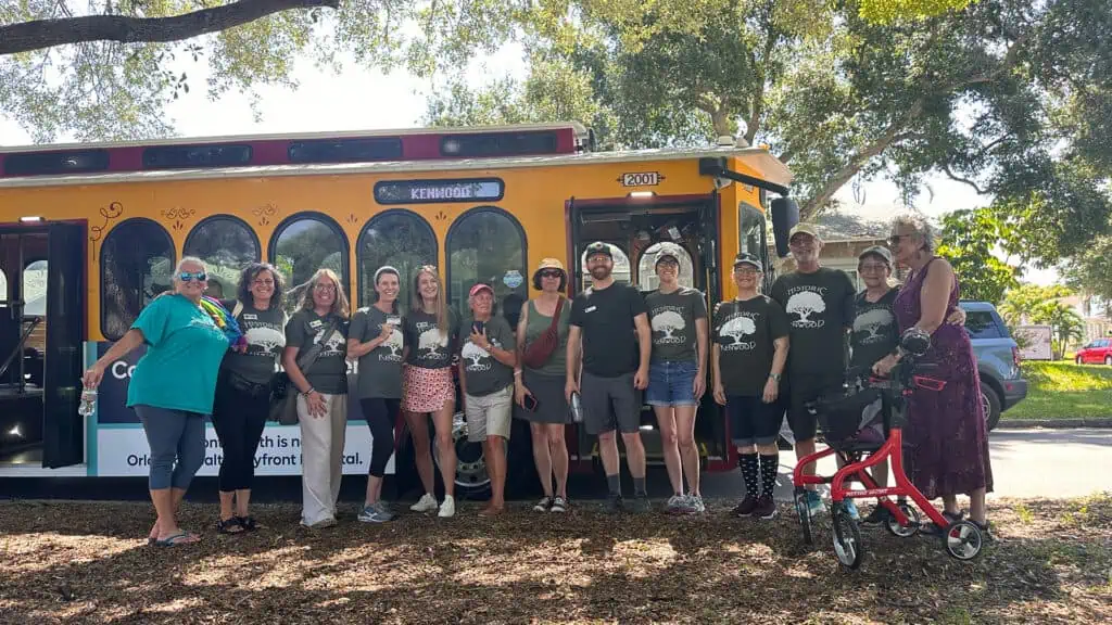 a group of people posing in front of a trolley