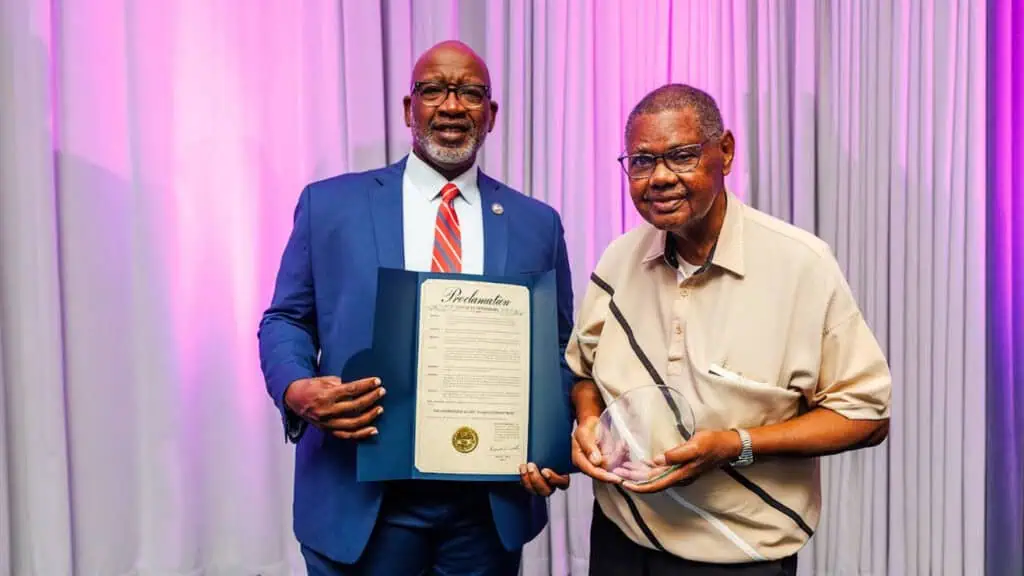 Mayor Ken Welch holding a Proclamation honoring the Courageous 12 and standing next to Leon Jackson, the remaining member of the 12