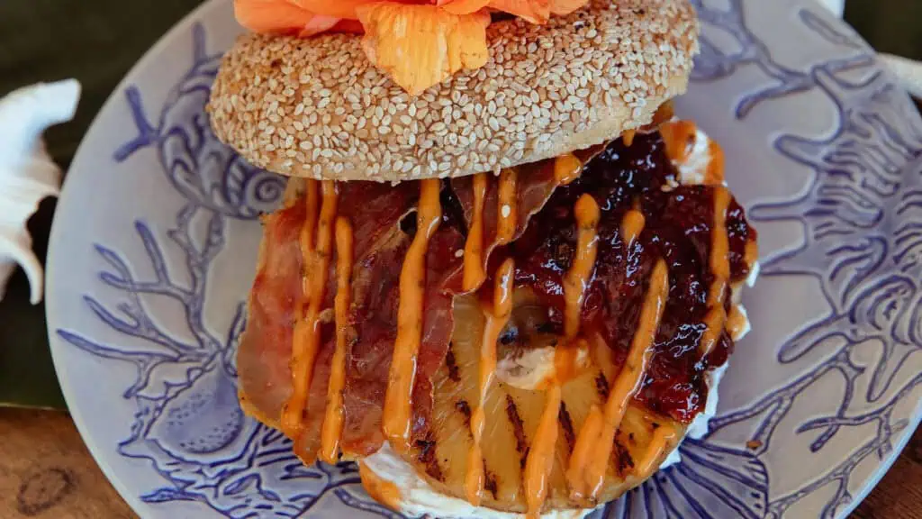 a bagel topped with different meats and orange sauce 