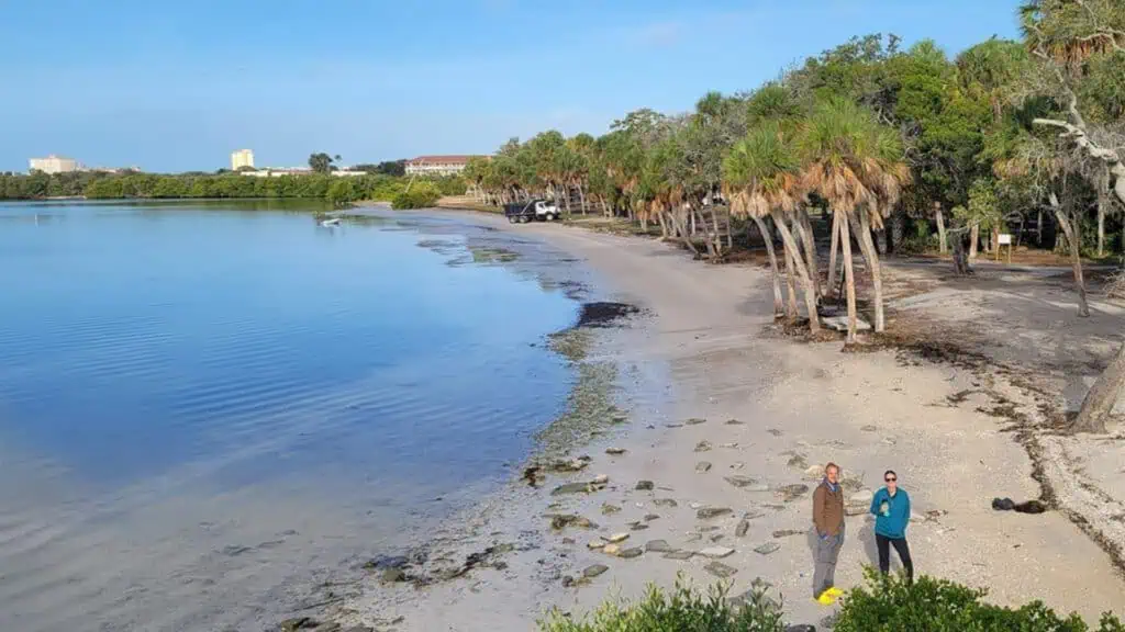 a waterfront area with two volunteers on the beach