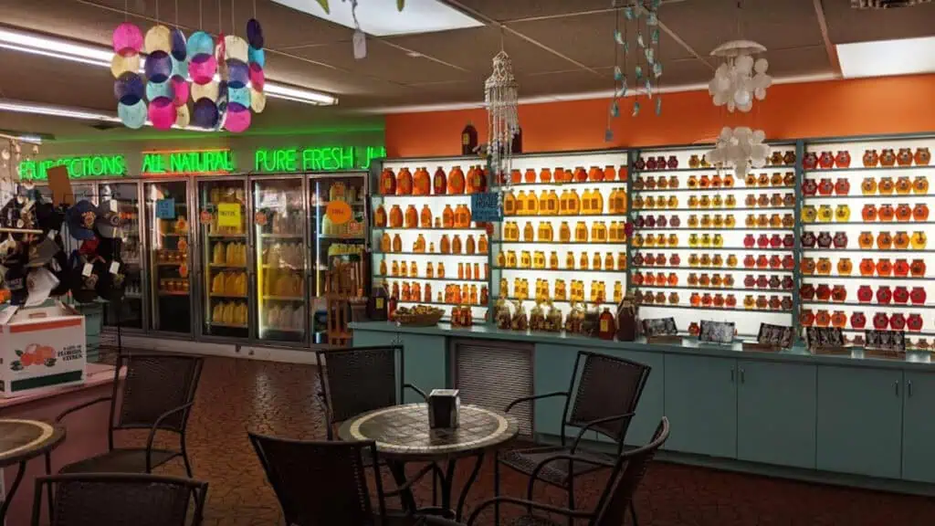 inside a fresh citrus market with rows of honey and candies on the wall 