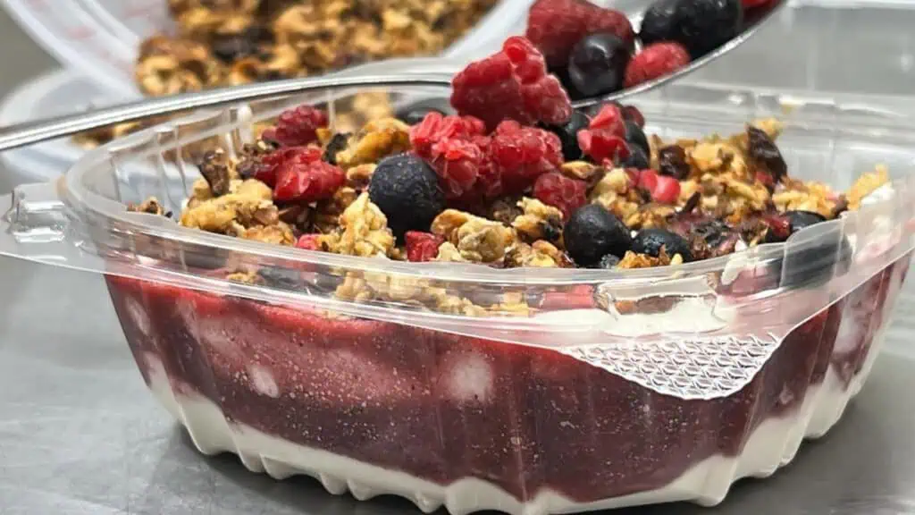 a yogurt bowl filled with fresh fruit and granola