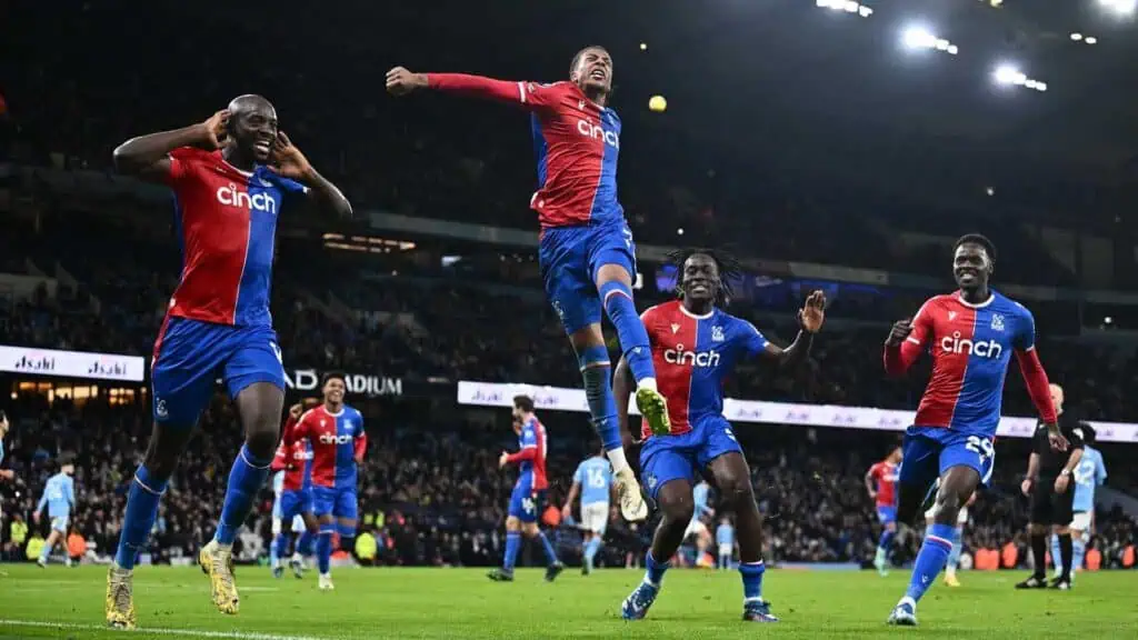 a group of soccer players celebrate on the field after a goal