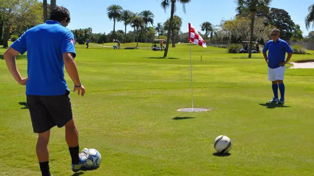 someone taps a soccer ball into a cup