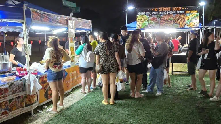 food vendors with a line of people outside at nighttime.