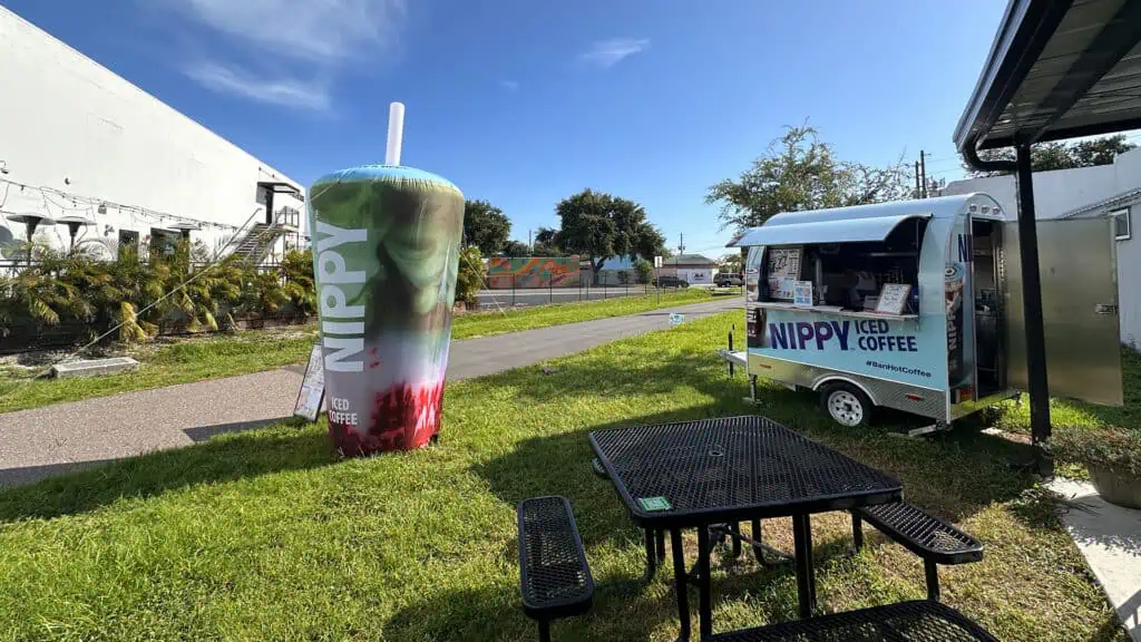 a coffee cart next to an inflatable coffee cup