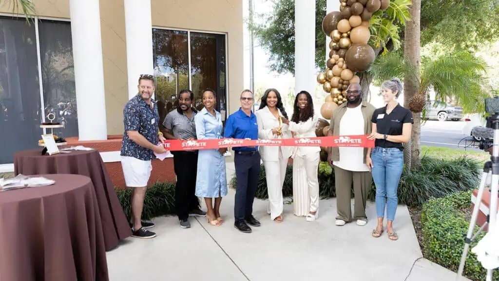 a group of people cut the ribbon on a new business 