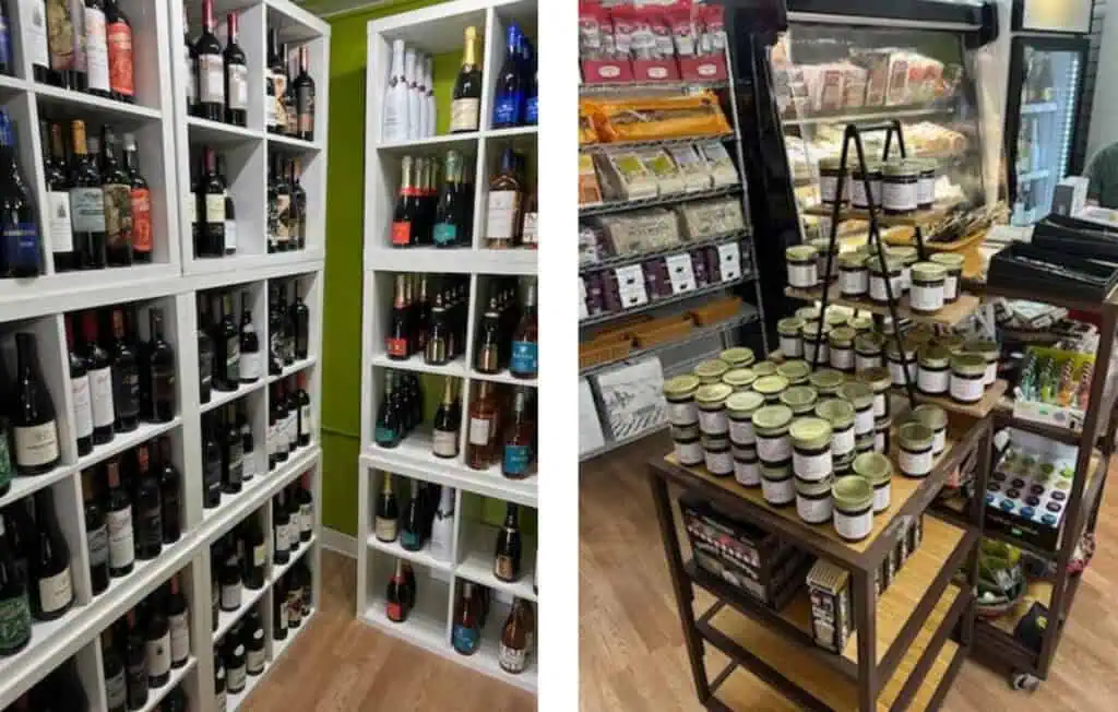 Shelves stocked with wine and table stacked with gourmet condiments.