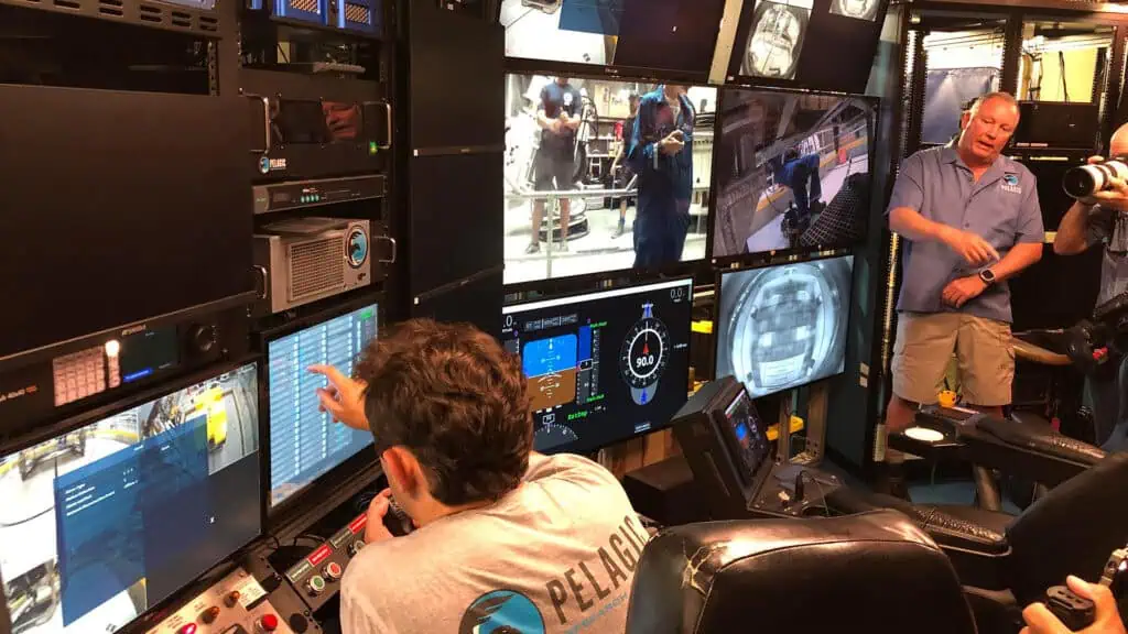 a person monitors multiple screens inside a marine science facility