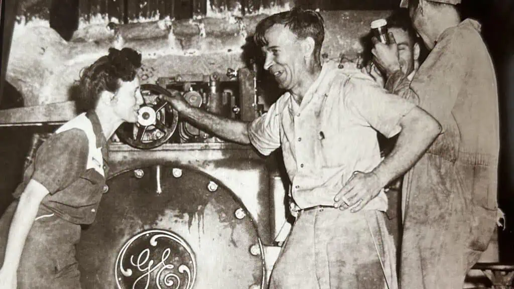 Woman and man in front of power generator in 1947