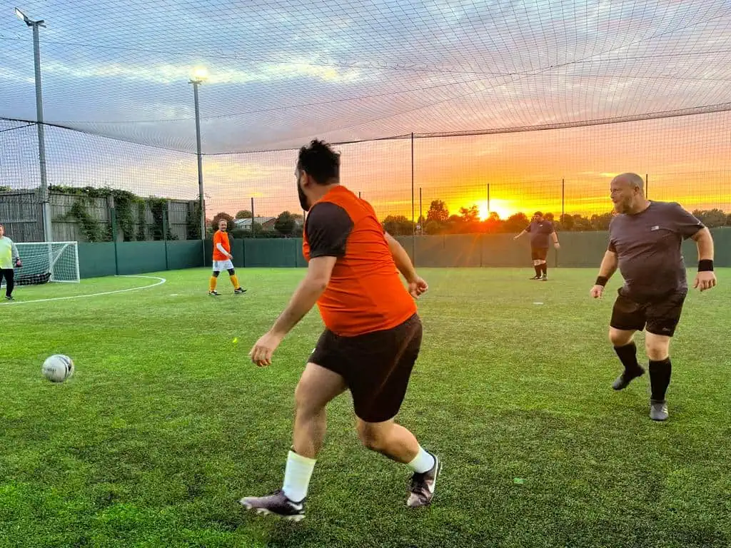 three men playing soccer on a field.