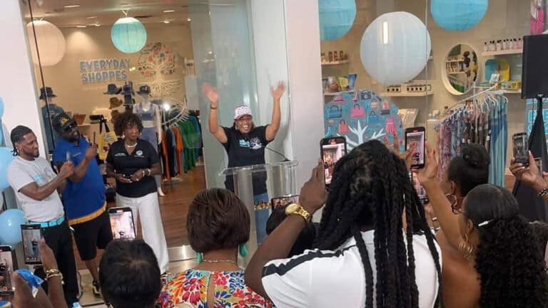 multiple people celebrating the ribbon cutting of a new local business boutique at a shopping center