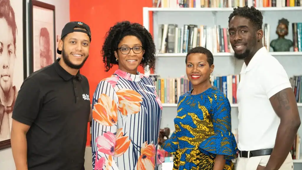 four people pose inside a museum during a big opening 