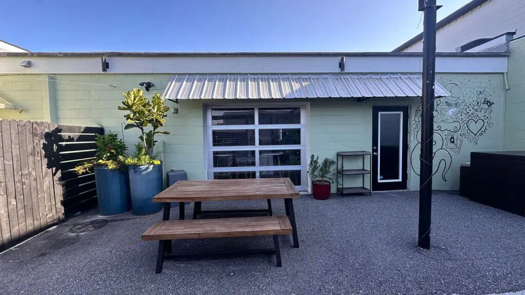 outdoor seating with a picnic table set in front of a large bay door