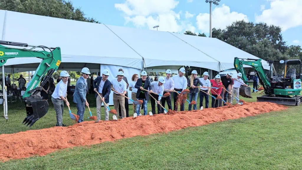 officials in hard hats break ground on a new sports complex 