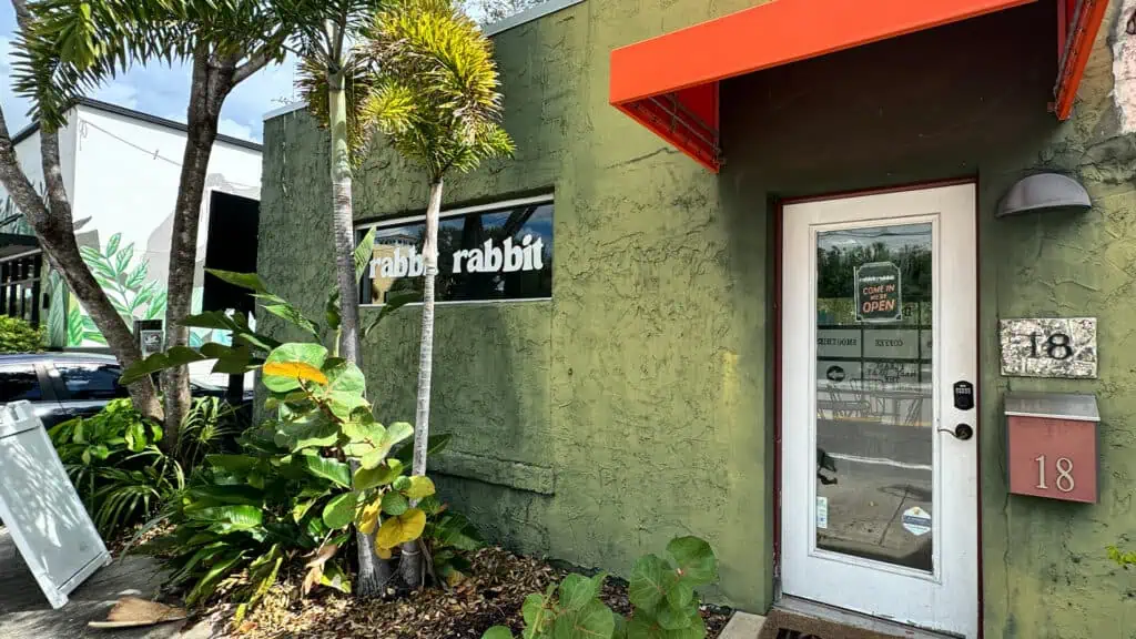 the green building exterior of rabbit rabbit with their shop name on the window in white