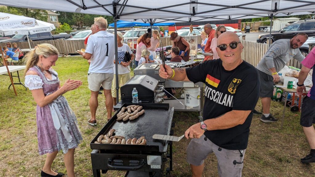 man cooking sausages on a grill outside