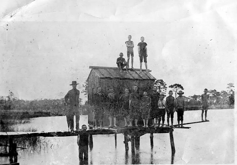 historic black and white photo of a group of people on a dock at Lake Wier.