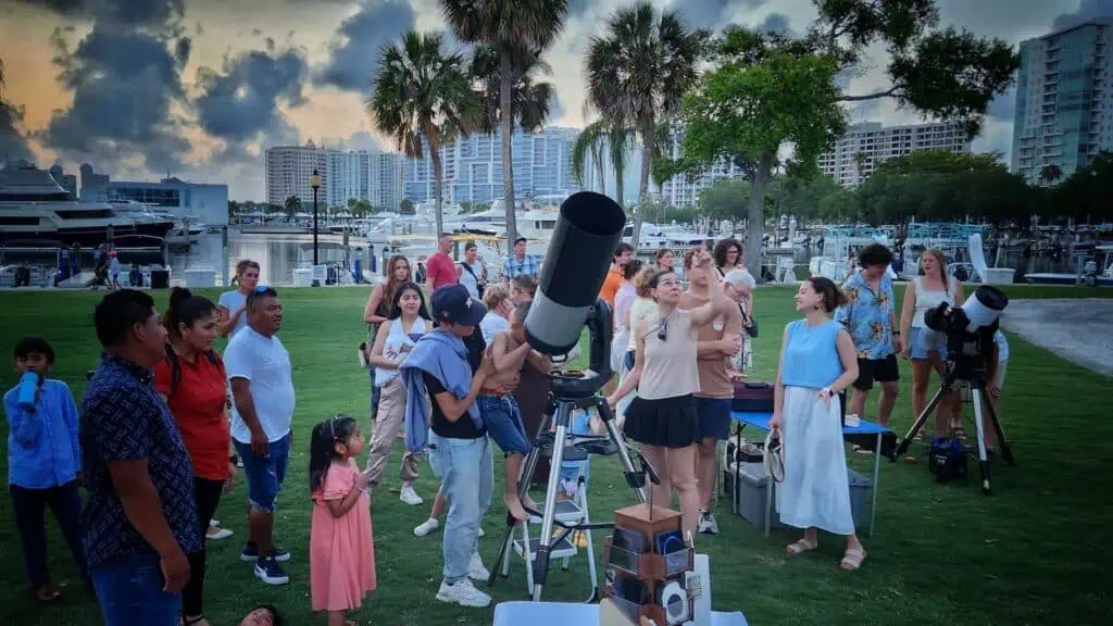 people looking through telescopes.