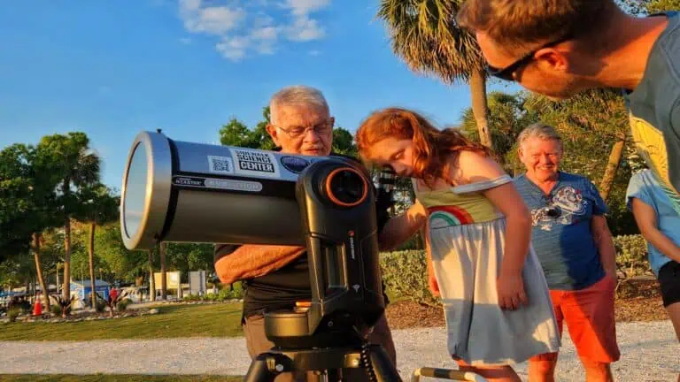 child looking through telescope