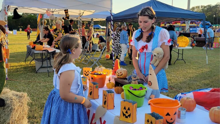 a group of people at a Halloween event in the park.