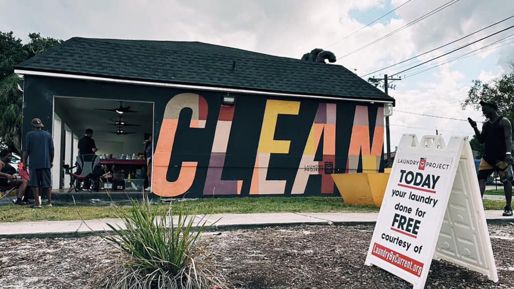 exterior of a laundromat with a "clean" mural on the side of the building