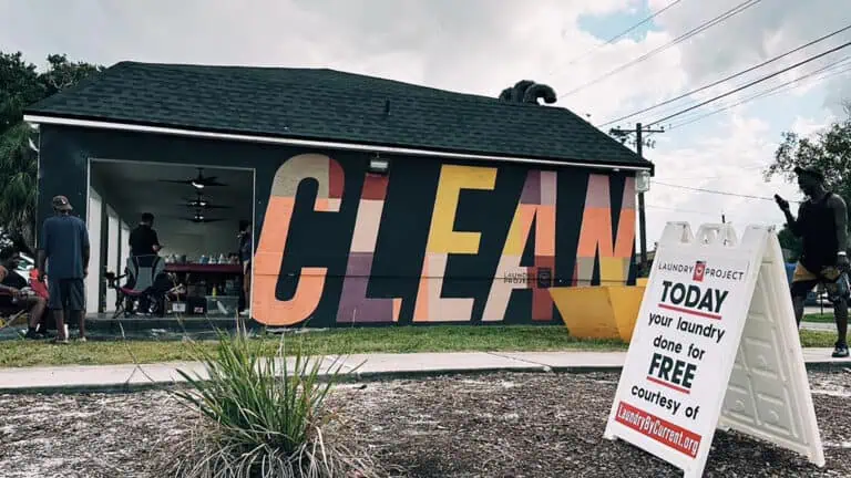 exterior of a laundromat with a "clean" mural on the side of the building