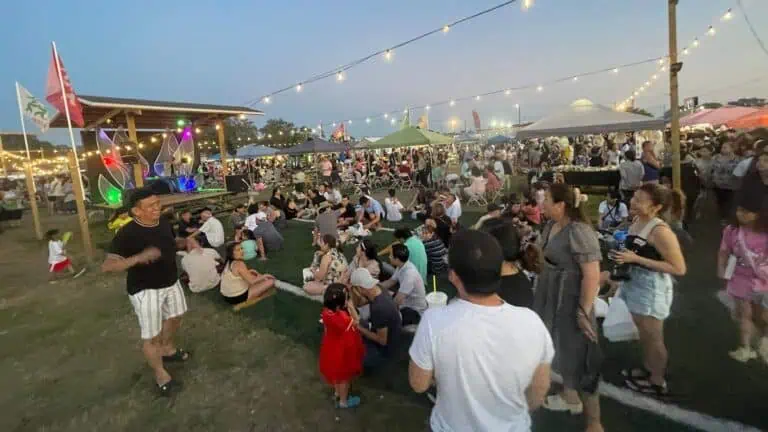 outdoor market with people and string lights