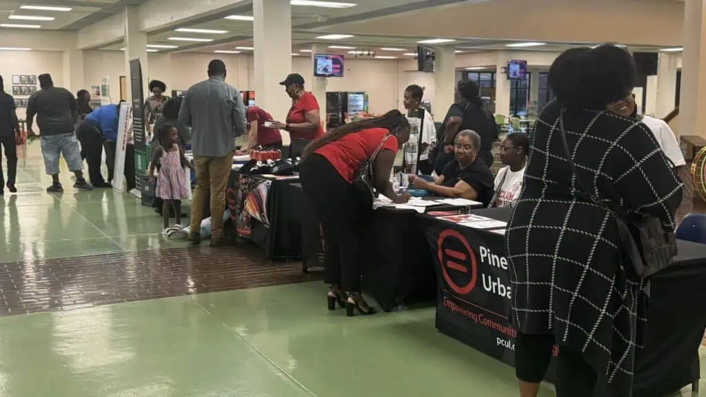 a group of people browse voter registration tables