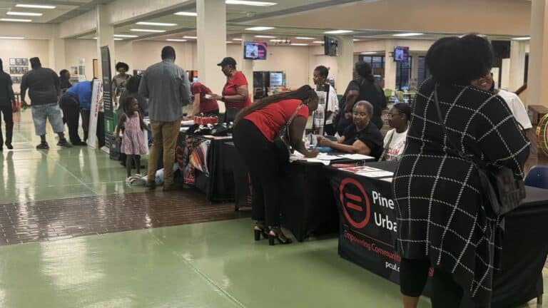 a group of people browse voter registration tables