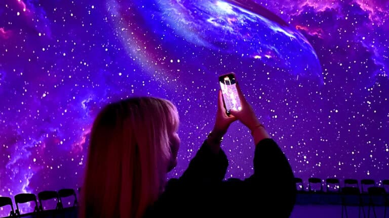 a person inside a dome with their phone videoing a purple screen