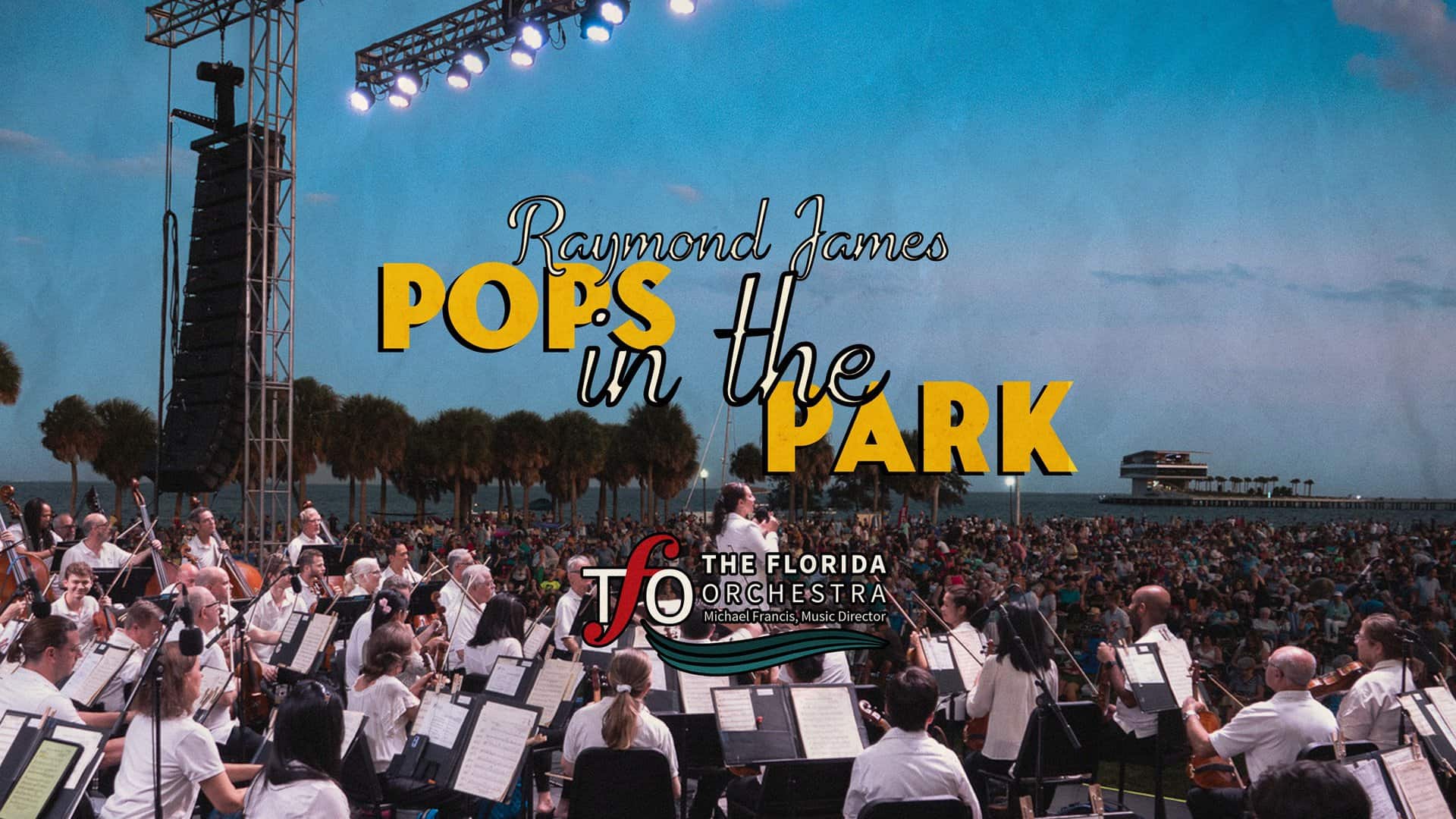 "The Florida Orchestra performs outdoors at sunset with a large audience gathered for the Pops in the Park concert."