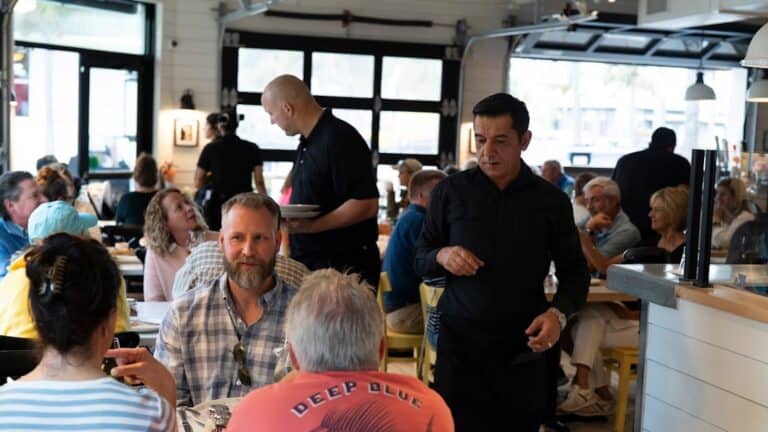 a waiter works inside a bustling restaurant