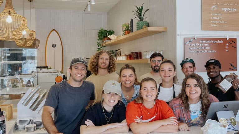 a group of people behind a counter at a cafe