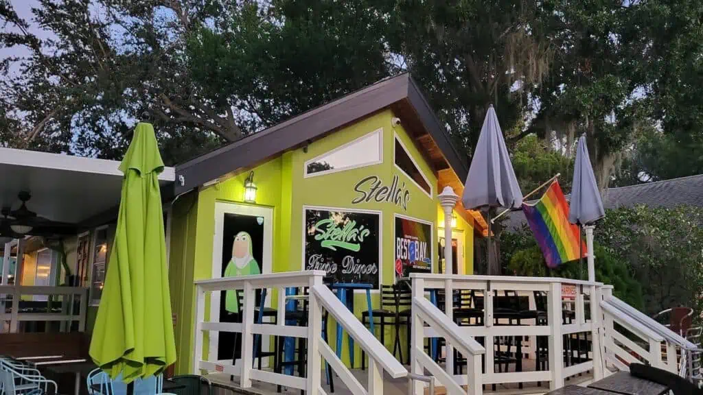 green building with deck and umbrellas